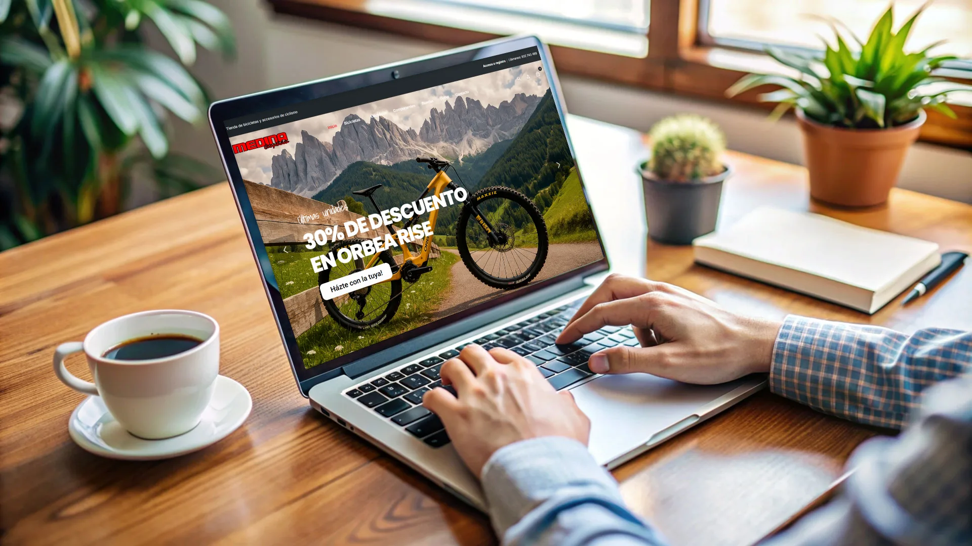 Portàtil sobre una taula amb la home de Medina Bicis a la pantalla: l’Orbea Rise groga amb el 30 % de descompte al slider